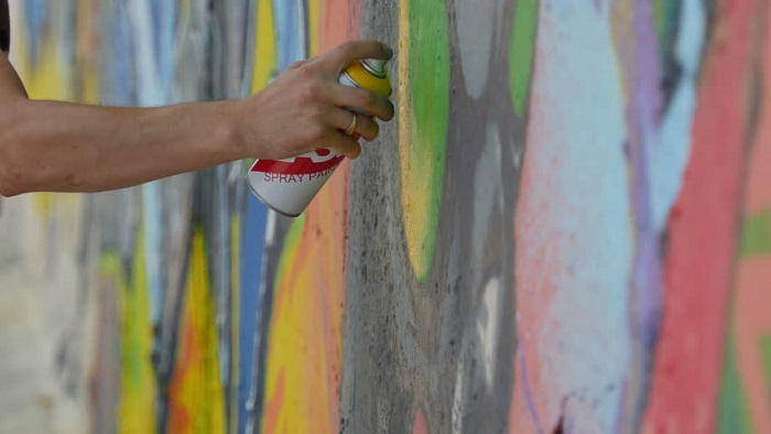 A Human Hand Hold Sprayer - Spray Painting On Wall.