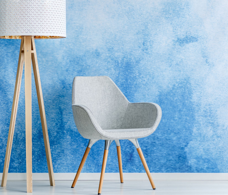 A Chair Placed Infront Of The Wall Painted By Blue Color.