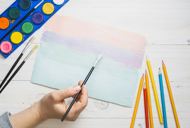 A Kid's Hand Hold The Painting Brush & Give The Color Shade Of Water.