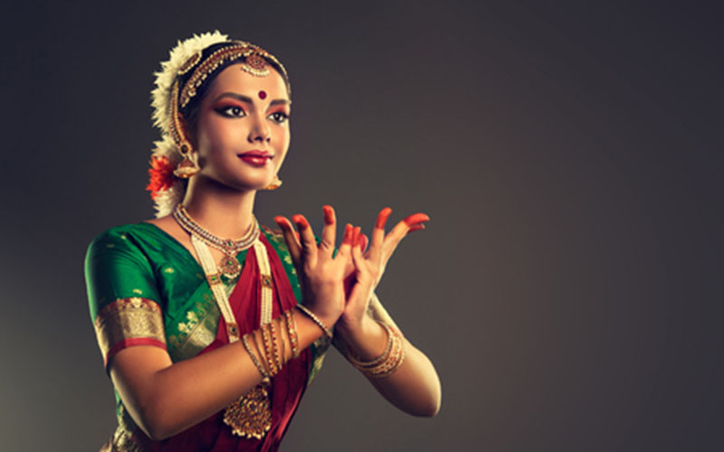 An image represents a girl performing Bharatanatyam pose with Alta in hands